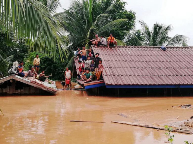Nhiều người dân ở vùng hạ lưu ở tỉnh Attappeu, Lào phải leo lên mái nhà tránh lũ. (Ảnh: Getty)